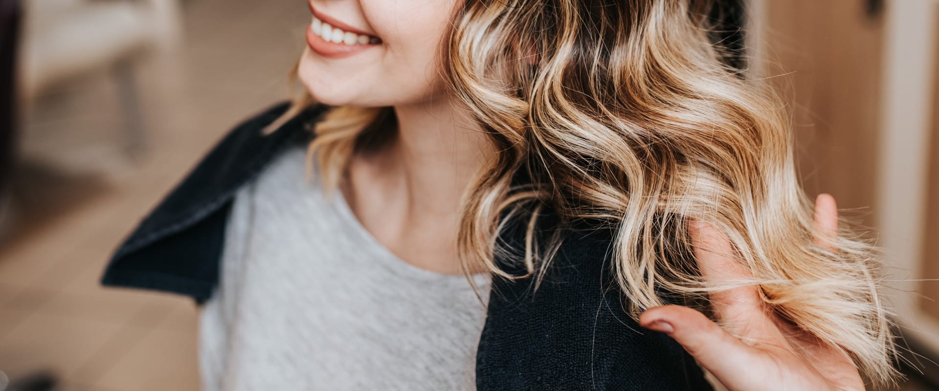 Beautiful hairstyle of young woman after dyeing hair and making highlights in hair salon.